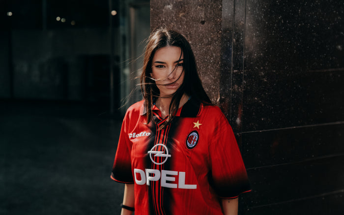 Modella indossa una maglia vintage AC Milan Opel, ritratta in un interno con parete scura